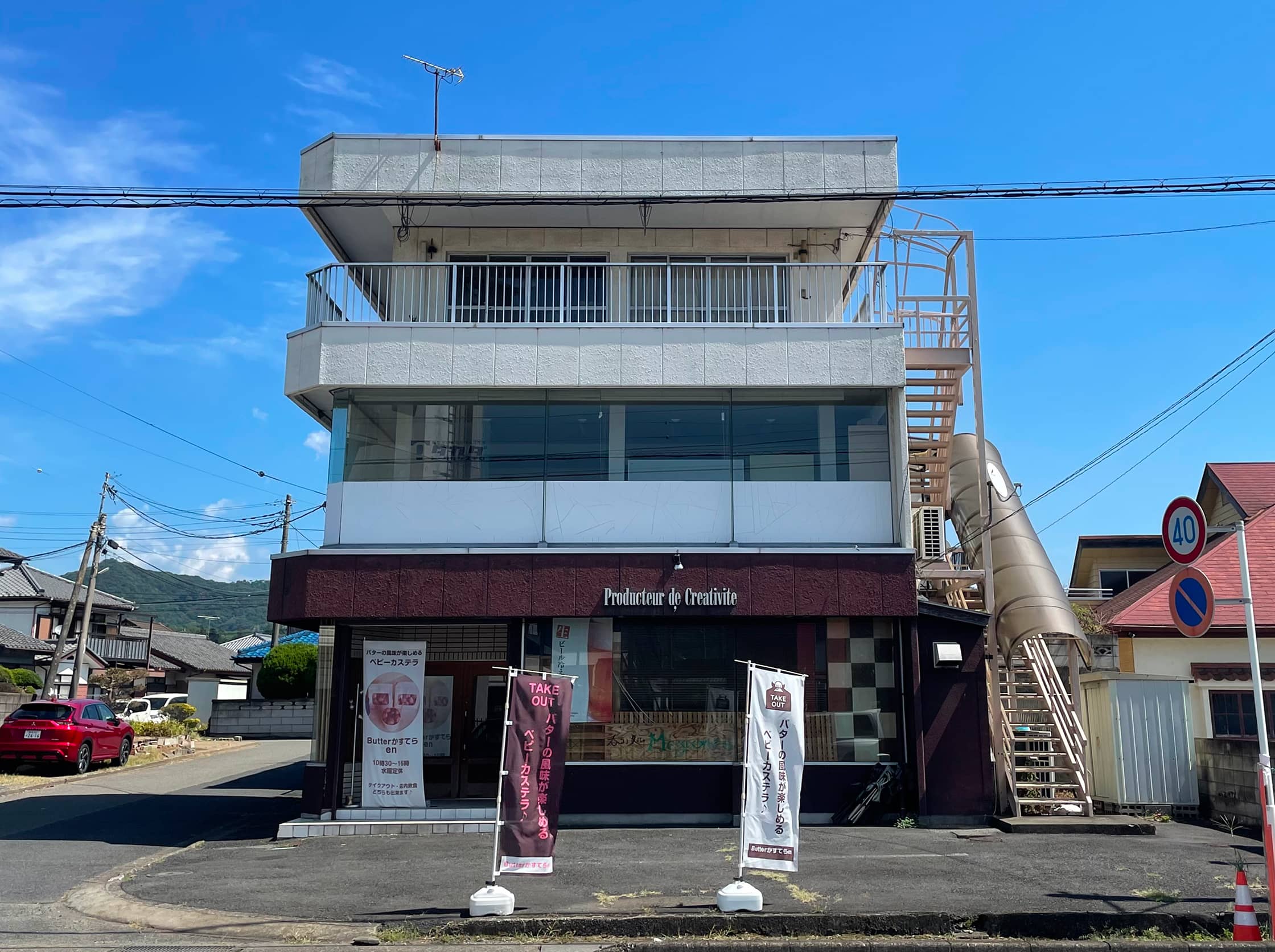 緑に囲まれたオフィスビルのエントランス部分。