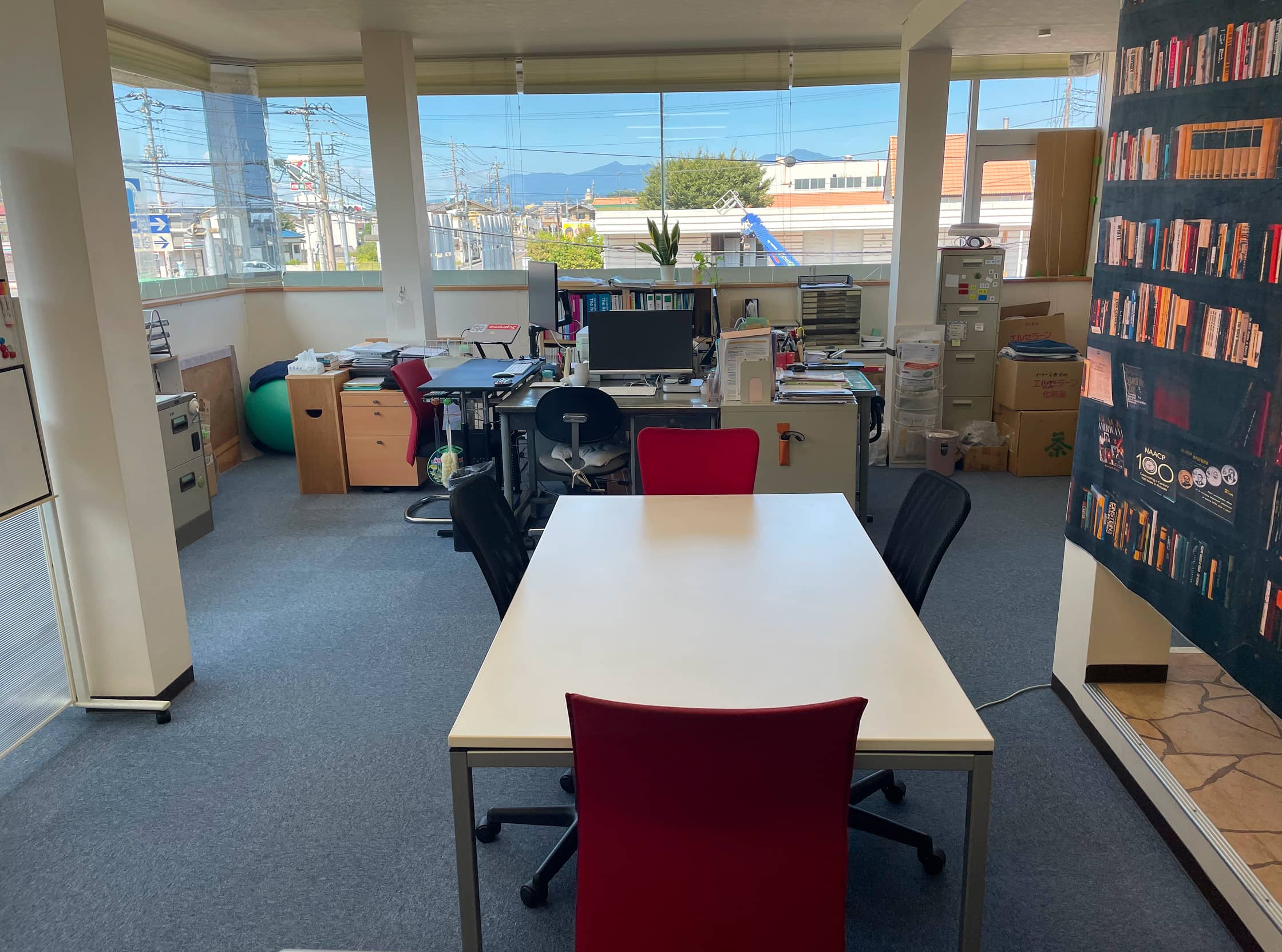 木目の受付カウンターと白い壁が印象的な事務室。