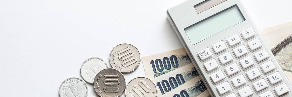 電卓と日本円を使って費用を計算する様子