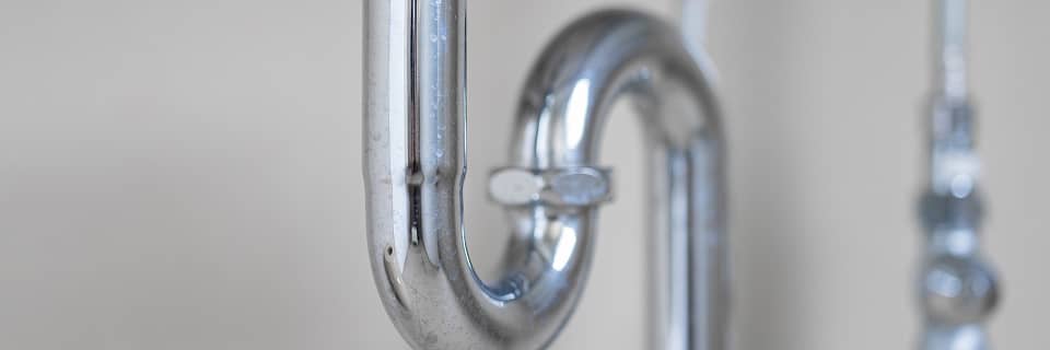 シンク下に設置されたU字型の排水パイプのクローズアップ